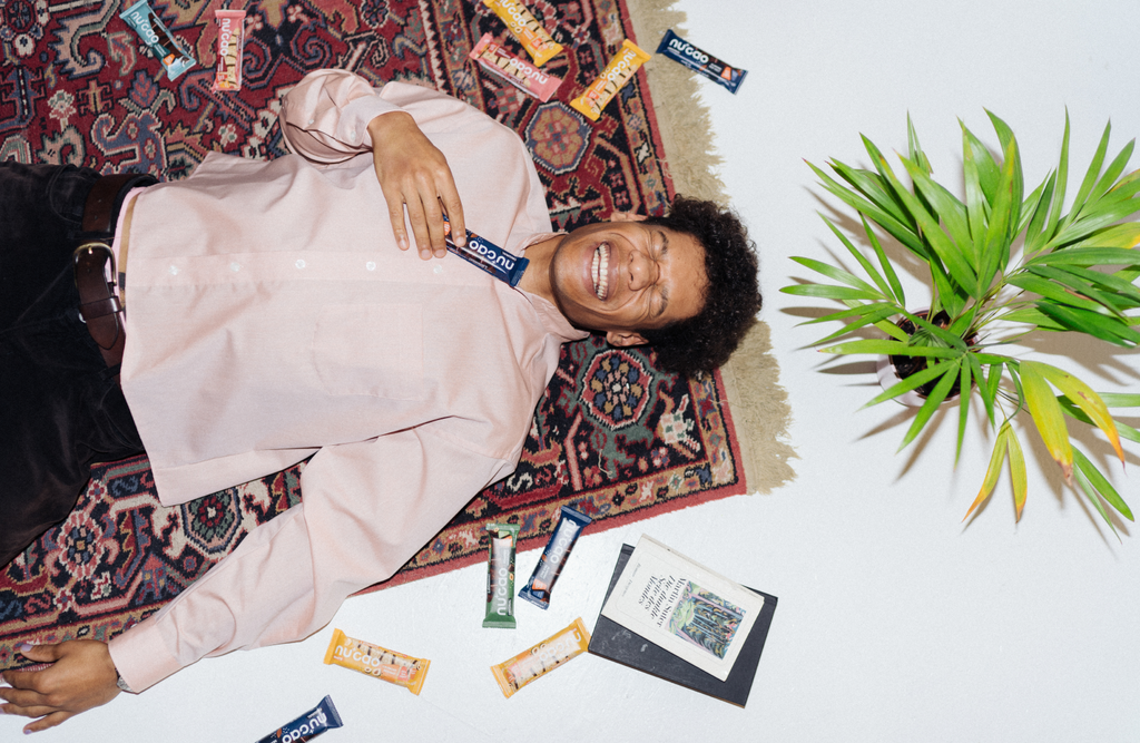 Ein Mann liegt auf einem Teppich und ist umgeben von Schokoladenriegeln